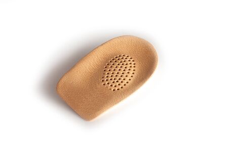 Orthopedic leather heel pad from corns for the correction of different lengths of legs isolated on white background. Leather insert for the forefoot. Medical insoles. Flat Feet Correction.の写真素材