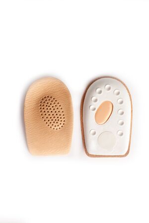 Orthopedic leather heel pad from corns for the correction of different lengths of legs isolated on white background. Leather insert for the forefoot. Medical insoles. Flat Feet Correction.の写真素材