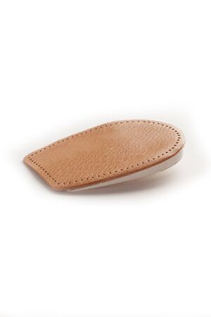 Orthopedic leather heel pad from corns for the correction of different lengths of legs isolated on white background. Leather insert for the forefoot. Medical insoles. Flat Feet Correction.の写真素材