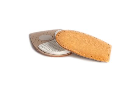 Orthopedic leather heel pad from corns for the correction of different lengths of legs isolated on white background. Leather insert for the forefoot. Medical insoles. Flat Feet Correction.の写真素材