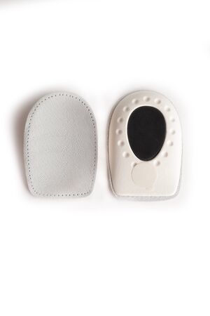 Orthopedic leather heel pad from corns for the correction of different lengths of legs isolated on white background. Leather insert for the forefoot. Medical insoles. Flat Feet Correction.の写真素材