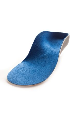 Isolated orthopedic insole on a white background. Treatment and prevention of flat feet and foot diseases. Foot care, comfort for the feet. Wear comfortable shoes. Medical insoles. Flat Feet Correction.の写真素材