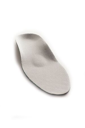 Isolated orthopedic insole on a white background. Treatment and prevention of flat feet and foot diseases. Foot care, comfort for the feet. Wear comfortable shoes. Medical insoles. Flat Feet Correction.の写真素材
