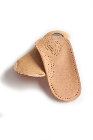 Medical insoles. Isolated orthopedic insoles on a white background. Treatment and prevention of flat feet and foot diseases. Foot care. Flat Feet Correction.の写真素材
