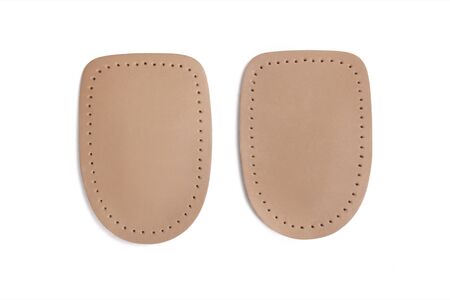 Orthopedic leather heel pad from corns for the correction of different lengths of legs isolated on white background. Leather insert for the forefoot. Medical insoles. Flat Feet Correction.の写真素材