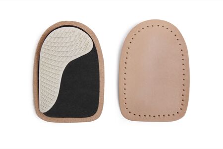 Orthopedic leather heel pad from corns for the correction of different lengths of legs isolated on white background. Leather insert for the forefoot. Medical insoles. Flat Feet Correction.の写真素材