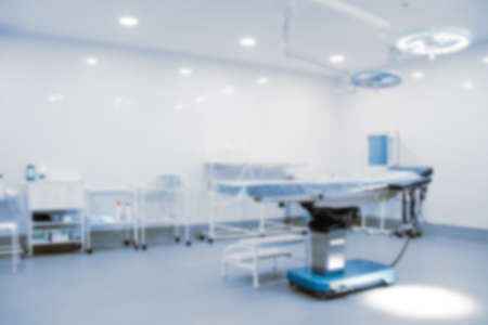 Blurred photo of the operating room in a hospital. Surgical equipment with operating table. Medical device for emergency patient in blue tone style. Blank Surgery Room. Clinic interior for background.の写真素材