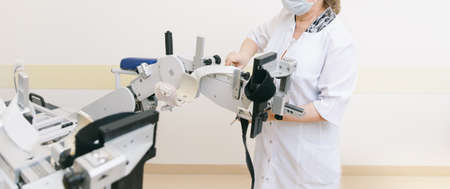 Patient on Continuous Passive Range of Motion machines. Device to provide anatomically correct motion to both the ankle and joints. Foot rehabilitation simulator after injured. Ligament treatment.の写真素材