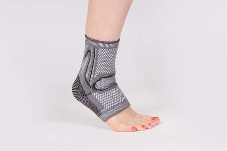 Orthopedic Ankle Brace. Medical Ankle Bandage. Medical Ankle Support Strap Adjustable Wrap Bandage Brace foot Pain Relief Sport. Leg Brace isolated on white background. Trauma Ankle orthosis. Injury.の写真素材