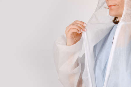 Female doctor wearing personal protective equipment in hospital. Medical service uniform. Protective face mask, face shield and surgeon gown.の写真素材
