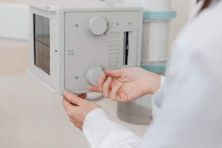 Hospital Radiology Room. Xray machine for fluorography. Doctor radiologist in gown adjusting the...