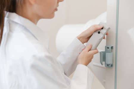 Hospital Radiology Room. Xray fluorography device remote control. Doctor radiologist in gown...
