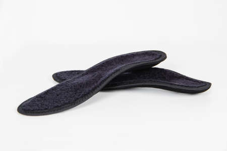 Black Insoles isolated on a white background. Medical orthopedic insoles. Foot care. Insole cutaway...