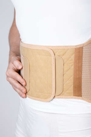 Orthopedic lumbar corset on the human body. Back brace, waist support belt for back. Posture...