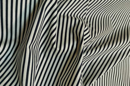 White fabric with black stripes. Crumpled or wavy fabric texture background. Abstract linen cloth...