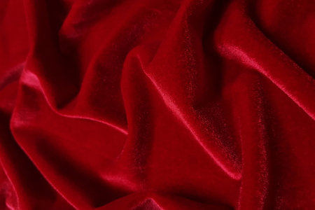 Red velvet crumpled or wavy fabric texture background. Abstract linen cloth soft waves. Merino yarn. Smooth elegant luxury cloth texture. Concept for banner or advertisement.の写真素材