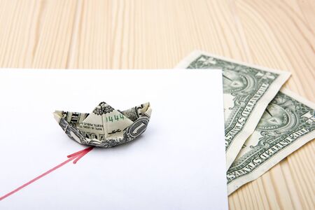 Dollar. A boat folded from one dollar holds the way on schedule. The dollar graph indicates a red...