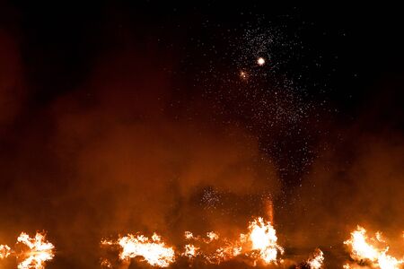 The big blazing fire in black night looks like a space galaxy with many starsの写真素材