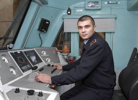 Khabarovsk, Russia. 12-11-2010. The electric train driver, a middle-aged man of European appearance, is in uniform in his cockpit, his gaze is directed to the camera.のeditorial素材