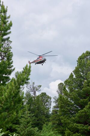 The Republic of Gorny Altai, Siberia, Russian Federation. 06-26-2017. Russian helicopter MI-8 flies, laying a turn, over the mountains of Altaiのeditorial素材
