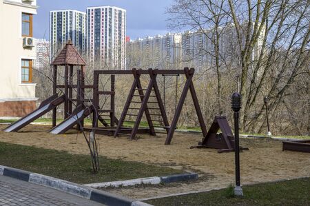 An empty playground in early spring. Children's slides, stairs, swings, sandbox and other buildings for children.の写真素材