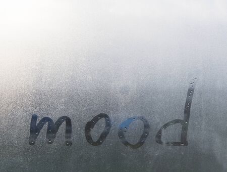 Mood. The word - mood - is written on wet misted glass. Traces of drops stretch from the lettersの写真素材