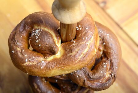 Freshly cooked pretzel at home in the kitchen. Pretzel with salt strung on a wooden pyramid