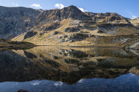 Seven Rila Lakes in Bulgaria - the peaks of the mountains are reflected in the lake. Reflection of the Rila mountains in clear water.の写真素材