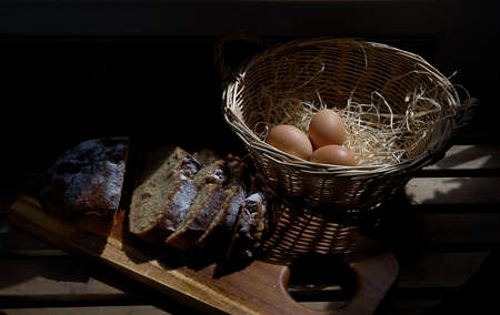 A beautiful picture on a table of eggs and fresh home-baked bread. The shadow falls artistically on...
