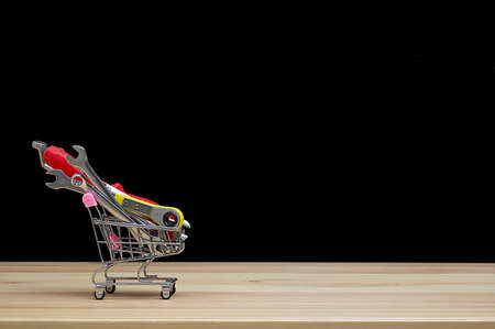 A small metal shopping trolley contains various construction tools - wrenches and screwdrivers....