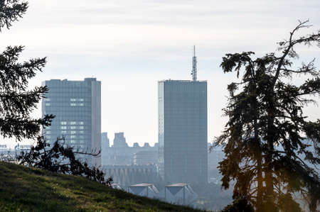 Belgrade. Serbia. 12.23.2020. The outlines of two high-rise buildings in the city center against a blue sky. A recognizable view of the city in the spring haze.のeditorial素材