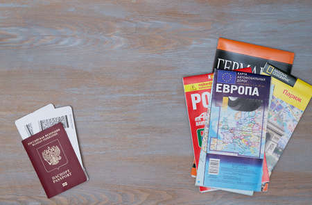 The passport for traveling abroad and the boarding pass for the plane lie next to different travel...