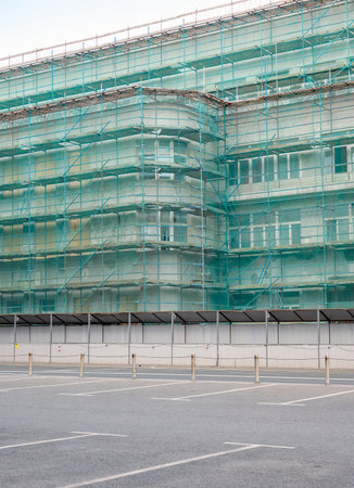 The building is covered with scaffolding and safety netting. Parking is located next to the...