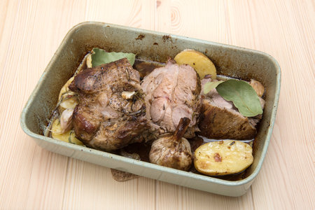 A ceramic dish with high walls in which lies freshly cooked delicious meat stew with fried vegetables.の写真素材