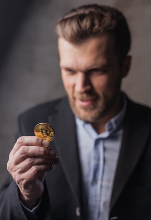 Greedy man looking at bitcoinの写真素材