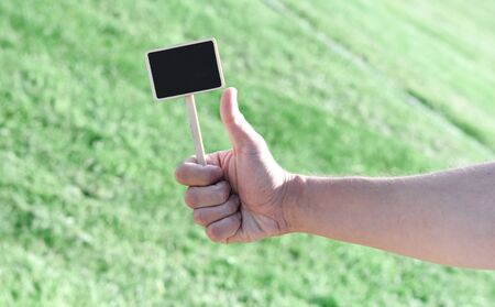 Hand holding empty board and showing thumb up
