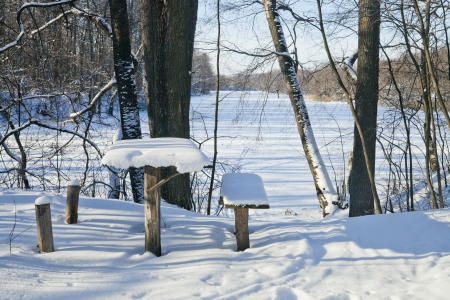 A wooden table by the lake in winterの写真素材