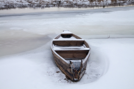 Wooden boat on the river in winterの写真素材