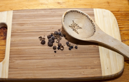 Pimento and wooden spoon on a cutting boardの写真素材