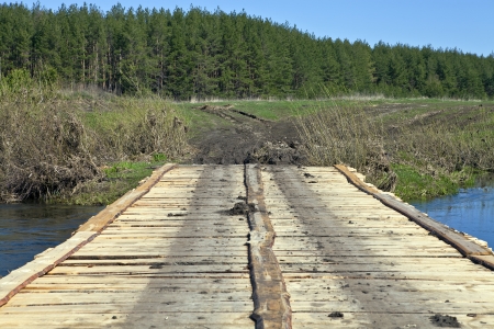 Wooden bridge of pine boards through a small riverの写真素材