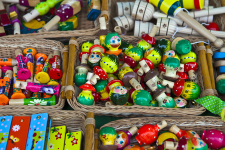 Many small wooden whistles of different colors in a wicker basketの写真素材