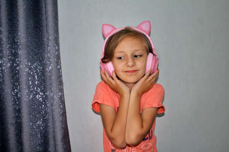 beautiful girl listens to music in pink headphones with ears like a catの写真素材