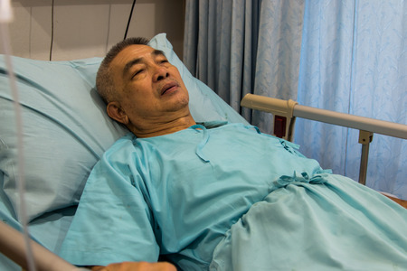 Old man patient sleeping in hospital bedの写真素材