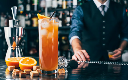 Fresh orange juice summer ice cold modern cocktail with sweet caramels decoration slice author drink on bar counter close up top view copy paste space design barman people and luxury nightclubの素材
