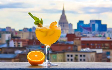Cocktail with orange and ice on the background of the cityの素材