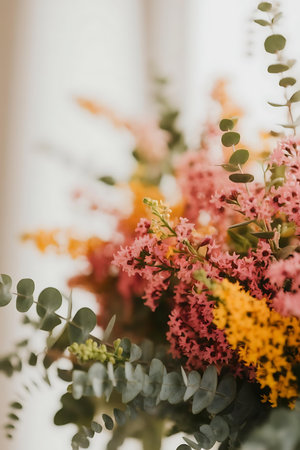 a vase filled with flowers and greeneの素材