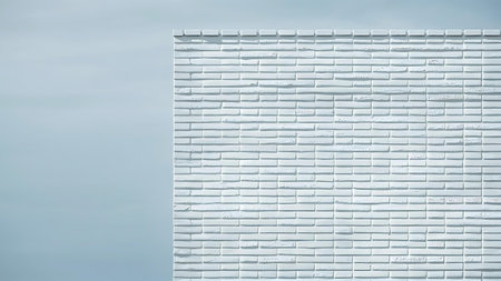 a white brick wall with a blue sky in the backgroundの素材