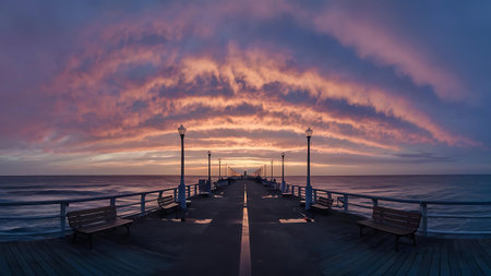 a pier with benches and a bench at the endの素材