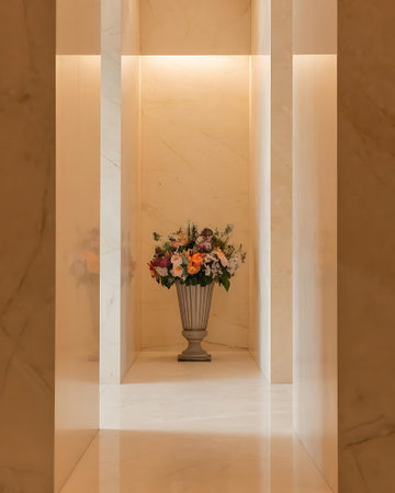 a vase with flowers in it sitting on a marble floorの素材