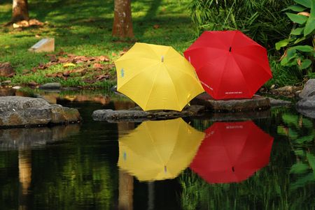 colorful umbrella reflection at the pond side の写真素材
